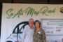 Joann and John Wallace posing in front of banner