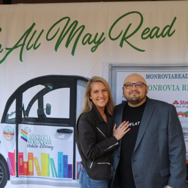 Jonathan and Sarah Rodriguez posing in front of banner