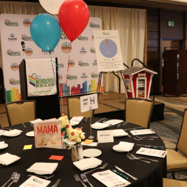 Table set up with balloon and a book.