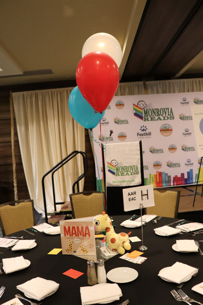 Table-with-Mama Table set up with book and balloons.